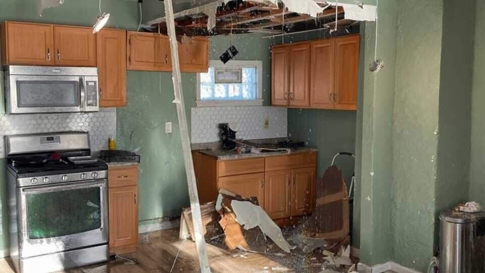 A residential living room flooded with water, furniture and belongings submerged